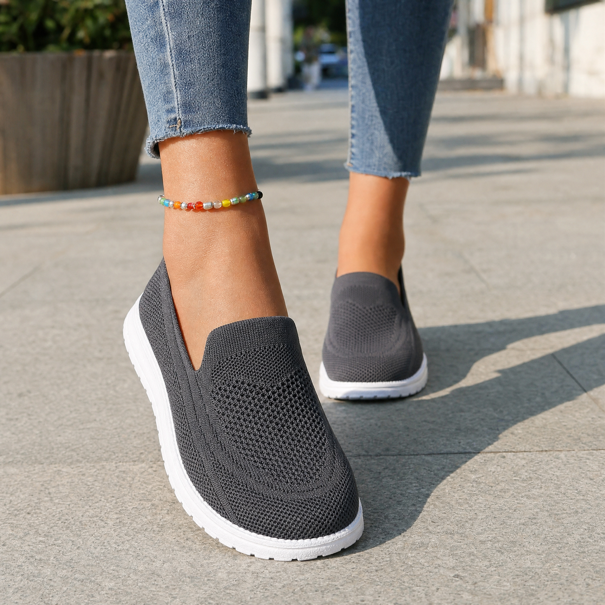 Woman wearing grey knit slip-on sneakers, lifestyle