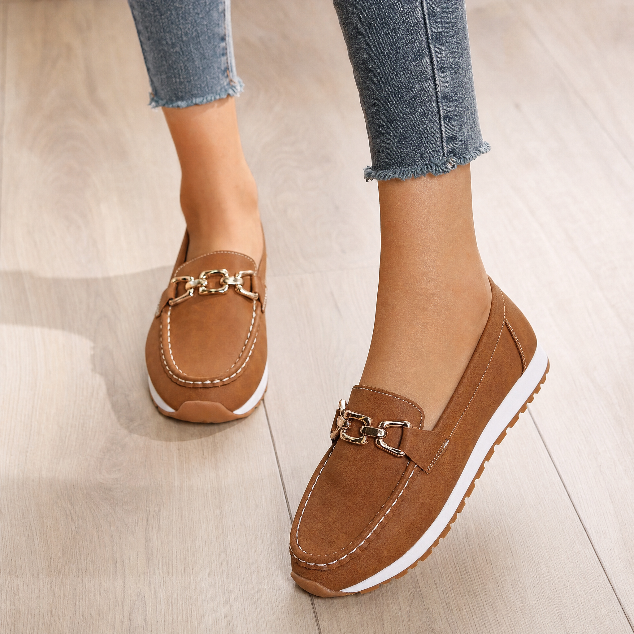 Woman wearing tan suede chain-bit loafers, lifestyle
